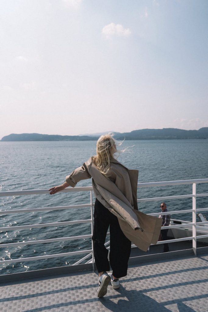 woman standing by the side of a watercraft