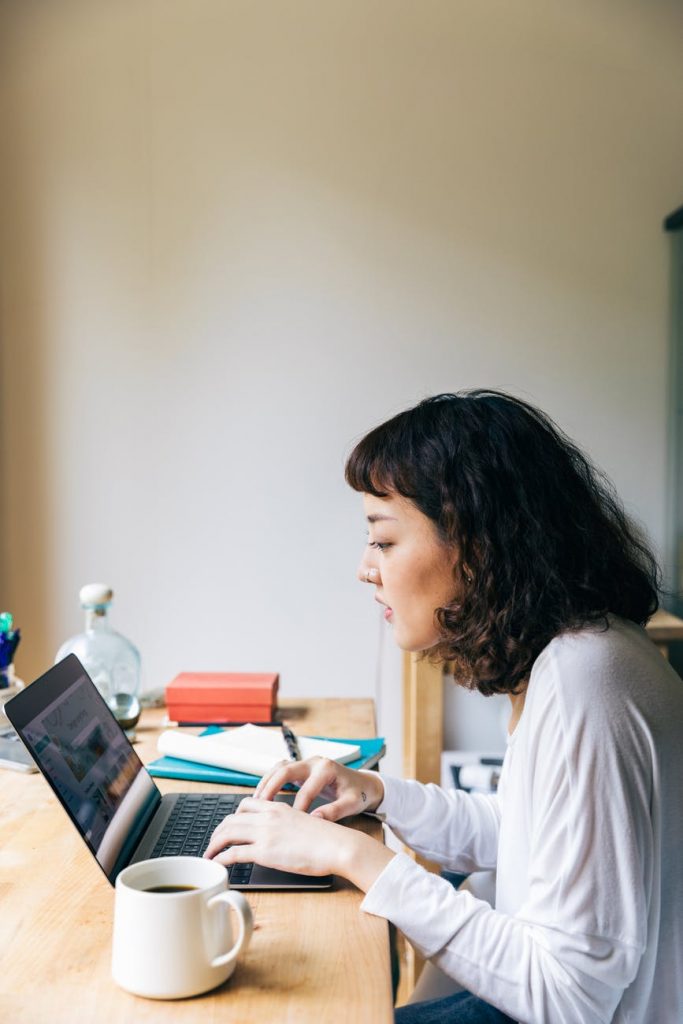 cheerful woman using laptop at home