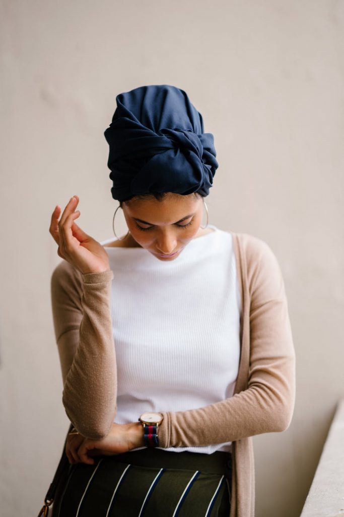 woman wearing blue turban white top and brown cardigan