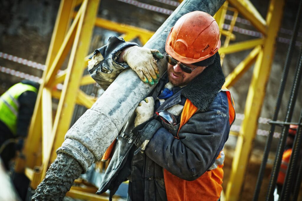 man carrying gray pipe