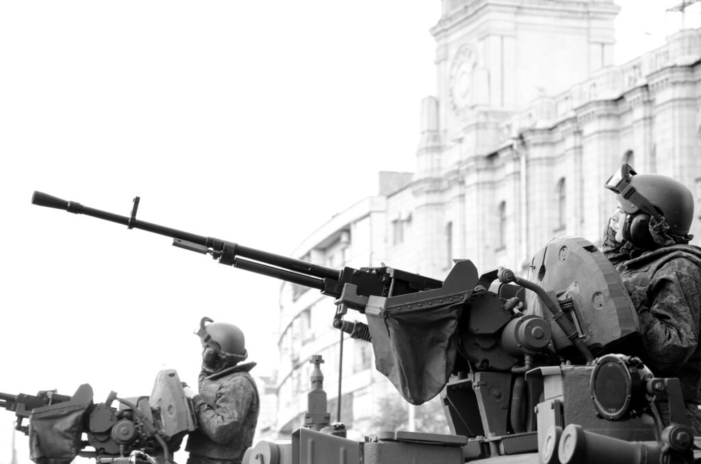 grayscale photo of man holding rifle