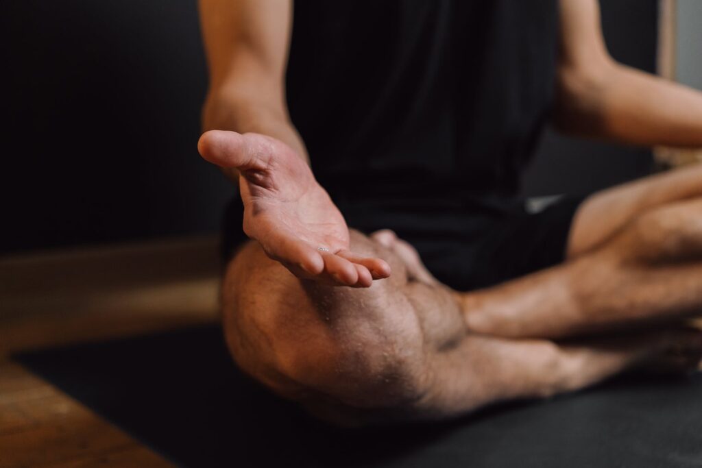 man practicing meditation on sports mat