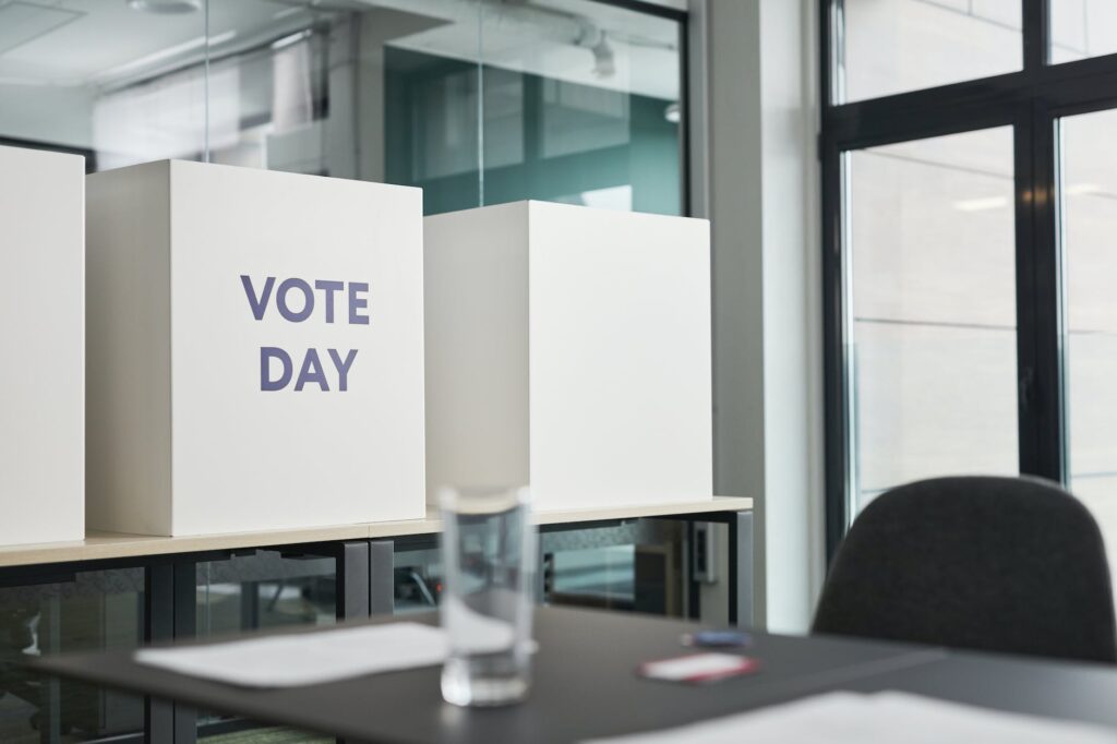 big boxes with a sign vote day standing on table in an office